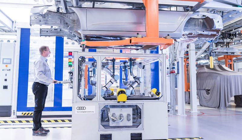 Cobots en industria automóvil ayudando en la producción.